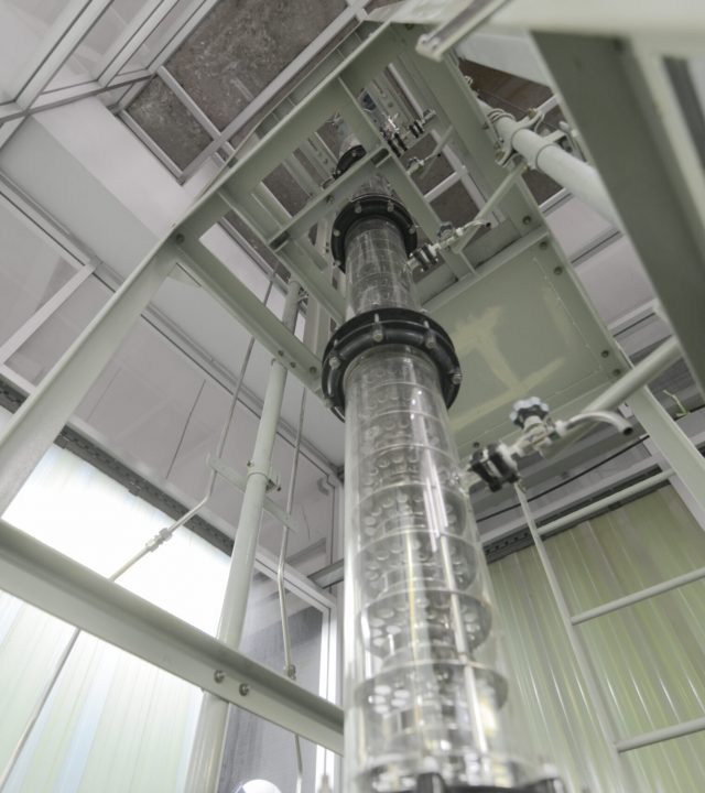 Wide angle view of extraction column in laboratory with ladder and metal plating around it